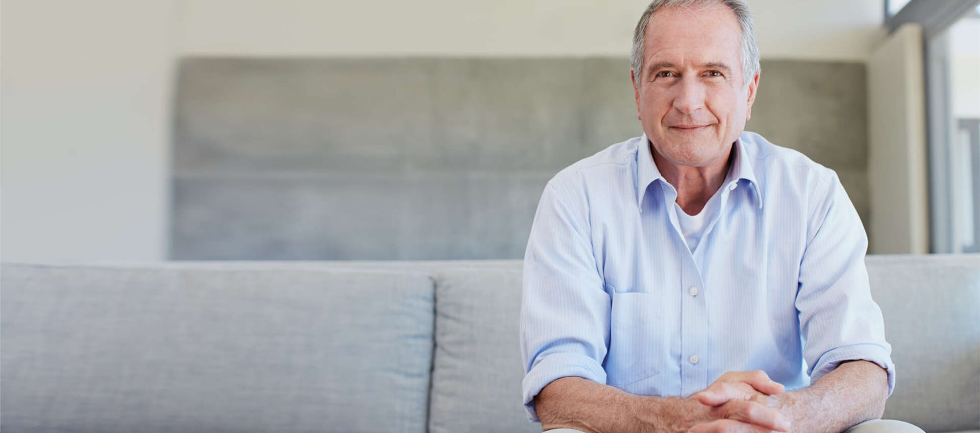 Man smiling while sitting on a couch