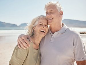 Older couple smiling at the beach