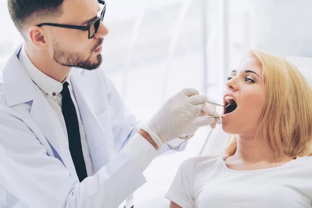 cosmetic dentist in Stuart checking his patient's mouth