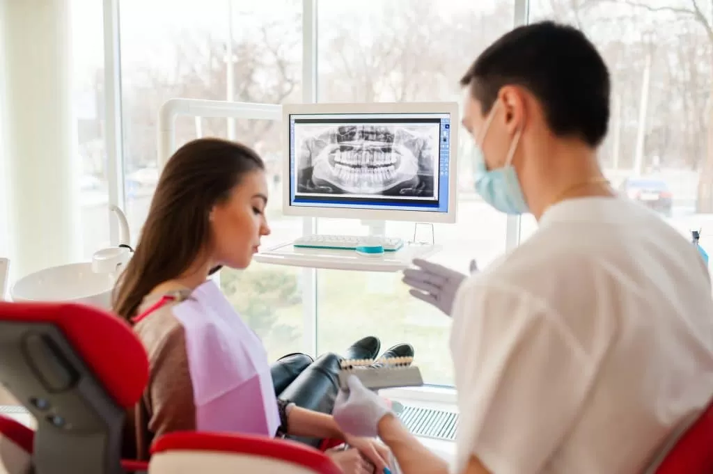 patient and dentist looking over dental x-rays