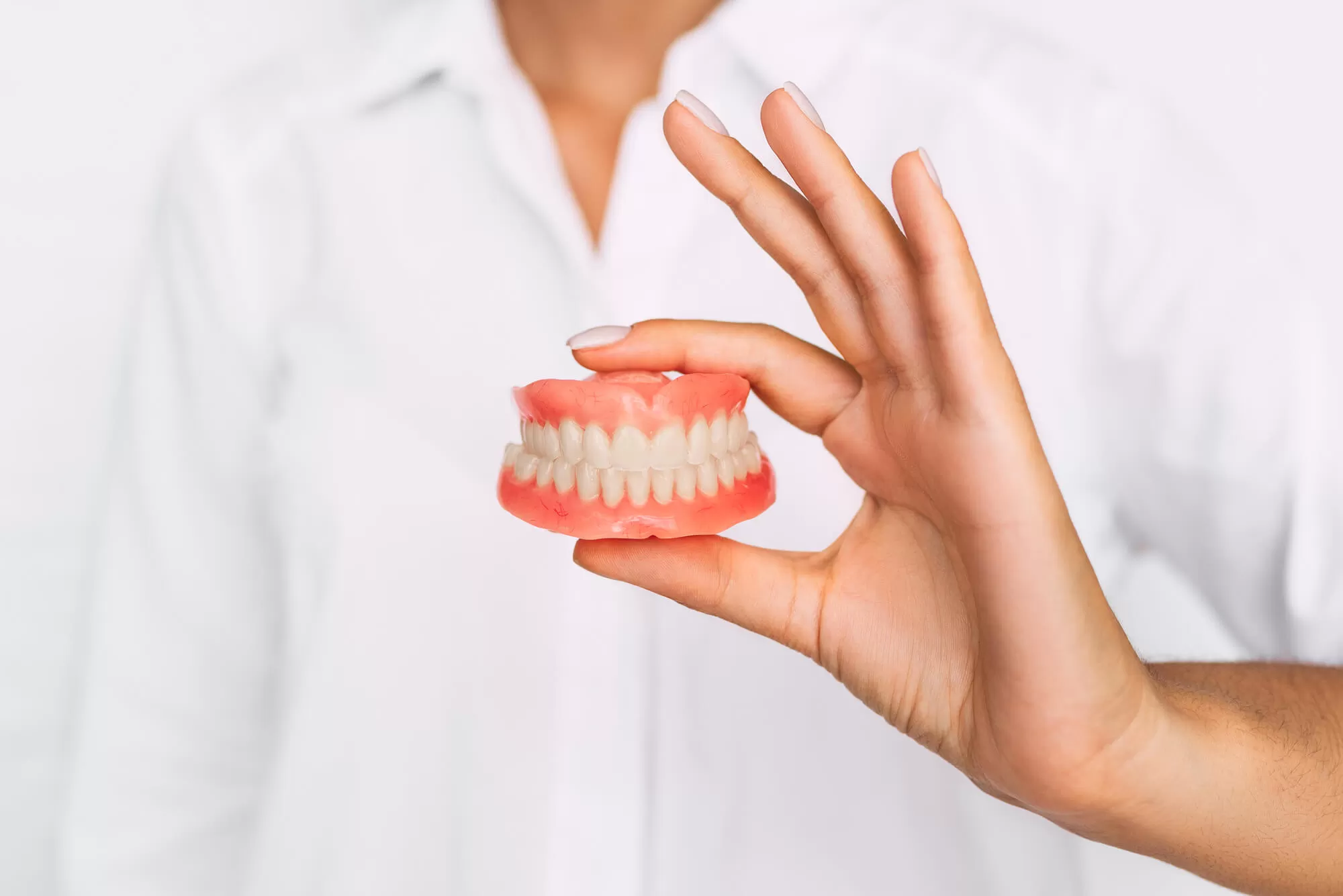dentist-holding-dentures-in-vero-beach