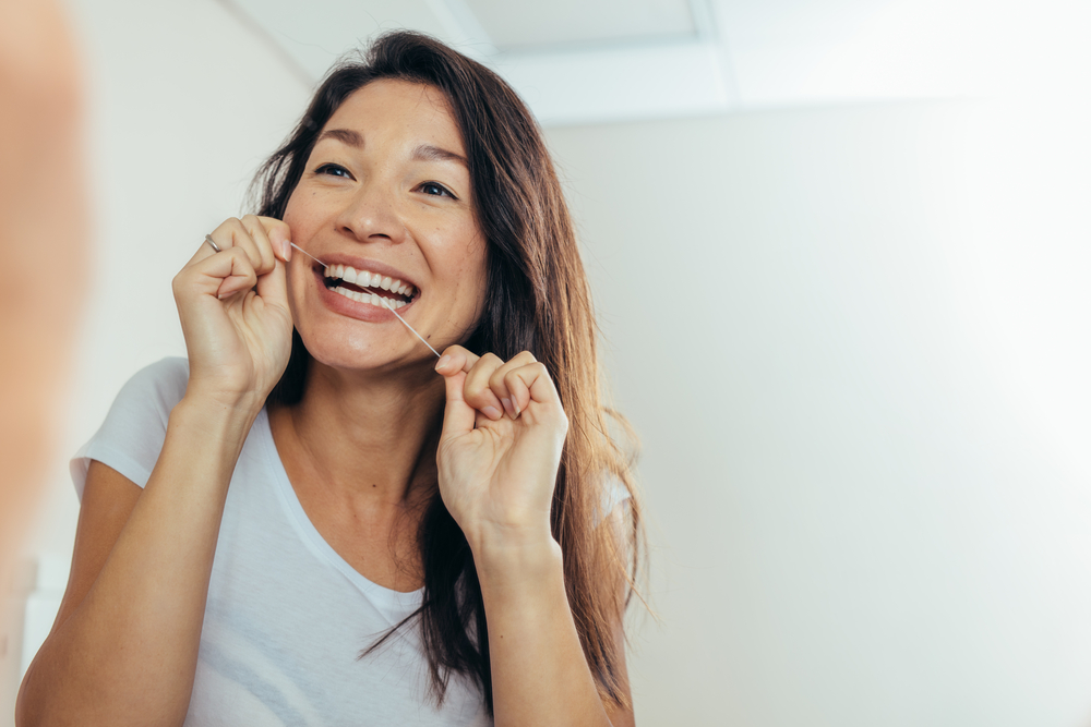 woman flossing for healthy teeth and gums